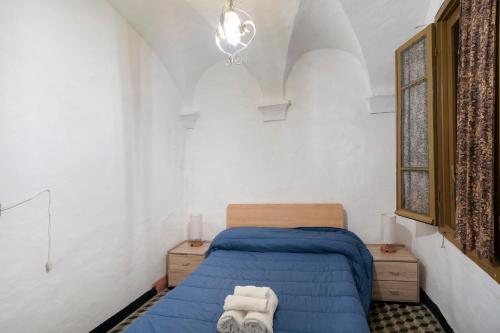 a small bedroom with a blue bed and a window at Casa Gianni in Vallebona