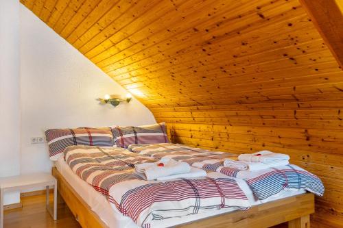 a bed in a room with a wooden ceiling at Ferienwohnung Das Nest in Schiltach