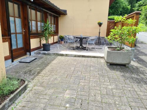 a patio with a table and chairs in front of a building at Hegauliebe in Tengen