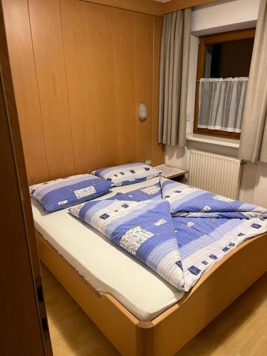 a bed with blue and white blankets and pillows on it at App Sonne Nr 17 in Lutago