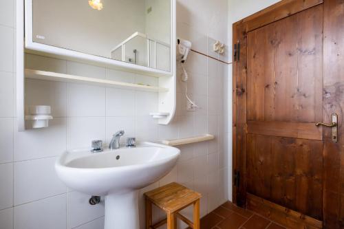 a bathroom with a sink and a wooden door at Appartamento Geranio in Radicofani