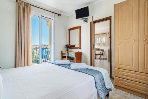 a bedroom with a bed and a balcony at Efrosyni apartment in Kefallonia