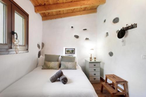 a bedroom with a bed and a wooden ceiling at La Casa de Abajo in Valverde
