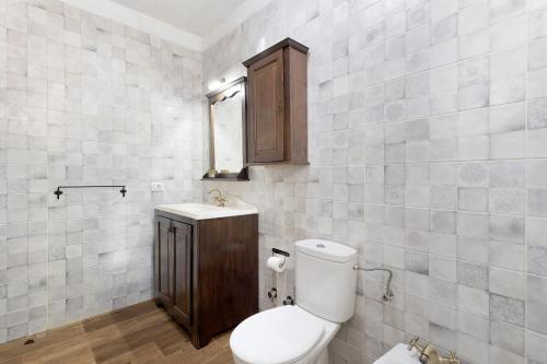 a bathroom with a toilet and a wooden cabinet at La Casa de Abajo in Valverde