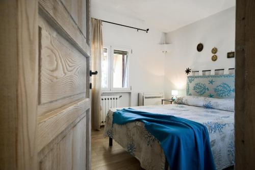 a bedroom with a bed with a blue blanket on it at Villa Amata in Arzachena