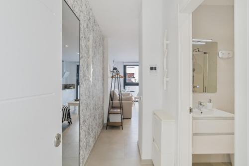 a white bathroom with a sink and a mirror at Apartamento Black and White 1 11 in Tarifa