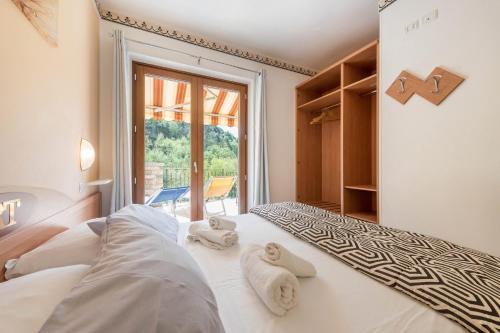 a bedroom with a bed with towels on it at Residence Tatiana A2 in Tremosine Sul Garda