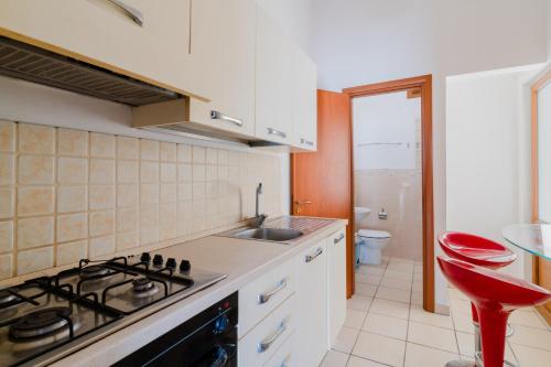 a kitchen with a stove and a sink and a toilet at La casetta 461 in Torre San Giovanni Ugento