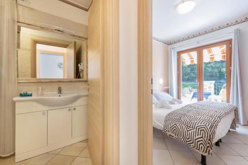 a bathroom with a sink and a bed and a mirror at Residence Tatiana A2 in Tremosine Sul Garda