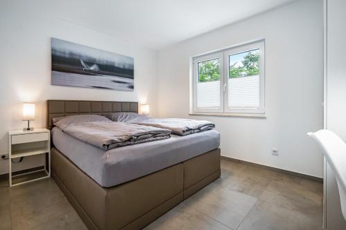a bedroom with a bed and a window at Seeglück 1 am Tollensesee in Groß Nemerow