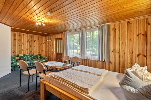 a room with a bed and a table and chairs at Bungalow 9 - Kimbucht in Reichendorf