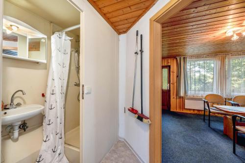 a bathroom with a sink and a shower and a table at Bungalow 9 - Kimbucht in Reichendorf