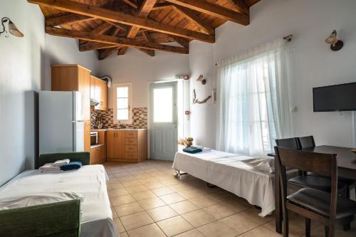 a kitchen with two beds and a table in a room at Afroksilia Villa Triantafilo in Lefkada