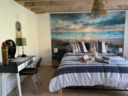 a bedroom with a bed with a painting on the wall at Chez Fatie in Listrac-Médoc