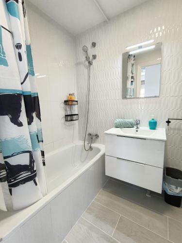 a white bathroom with a sink and a bath tub and a sink at R-23 Modern apartment in La Mata in La Mata