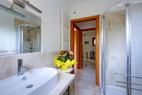 a white bathroom with a sink and a shower at Casa Antonella sul Golf in S'archittu Cuglieri