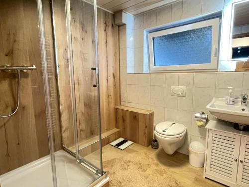 a bathroom with a shower and a toilet and a sink at Ferienwohnung Mark in Biberwier