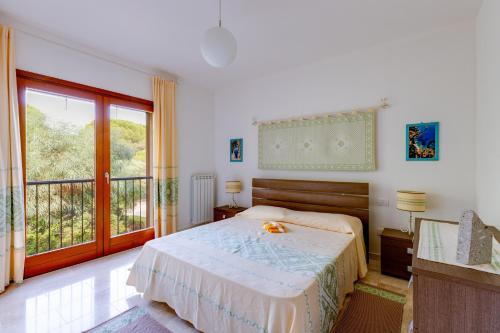 a bedroom with a bed and a large window at Casa Antonella sul Golf in S'archittu Cuglieri