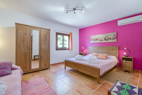 a bedroom with a bed and a purple wall at Sa Vinyeta in Artá