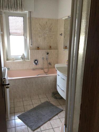 a bathroom with a pink tub and a sink at Balver Aussicht in Balve