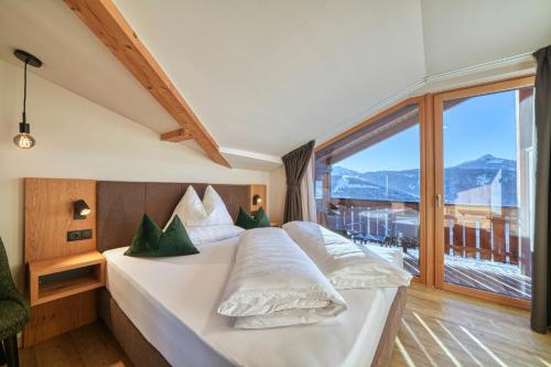 a bedroom with a large bed with a large window at Chalet Schlossberg Schlern in Nova Ponente