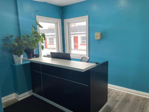 an office with blue walls and a desk with a laptop at Oshawa Inn Motel in Oshawa