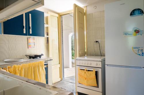 a kitchen with blue cabinets and a white refrigerator at Villa Grazia in Gallipoli