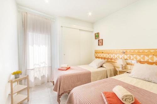 a hotel room with two beds and a window at El Paller de Cal Maso in Guisona