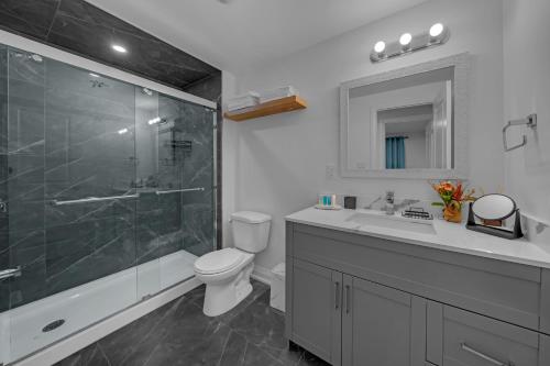 a bathroom with a shower and a toilet and a sink at Poolside Paradise minutes away from the Falls in Thorold