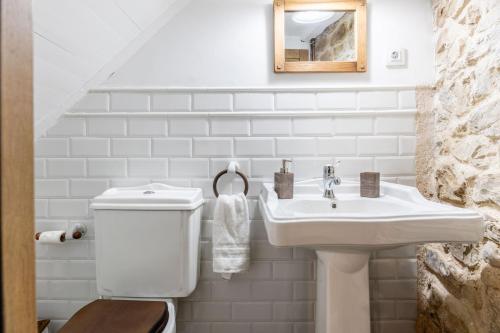 a white bathroom with a sink and a toilet at Casa Raymonde in Potes