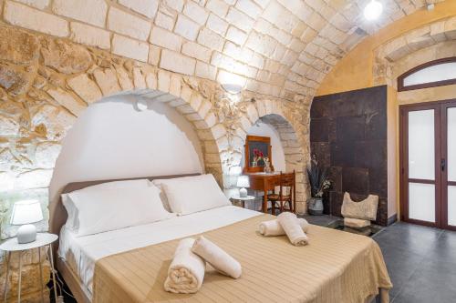a bedroom with a bed with towels on it at Dammuso 3cirniechi in Ragusa