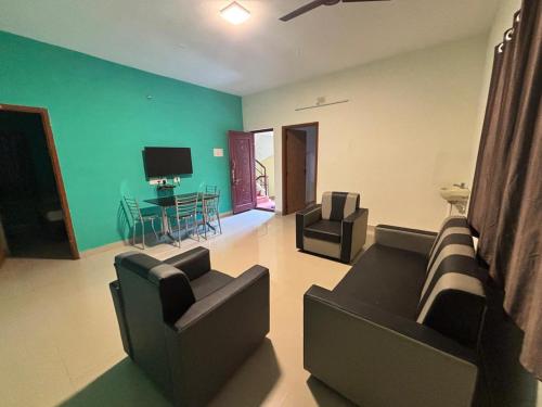 a living room with two couches and a flat screen tv at Thamira Residency Yercaud in Yercaud