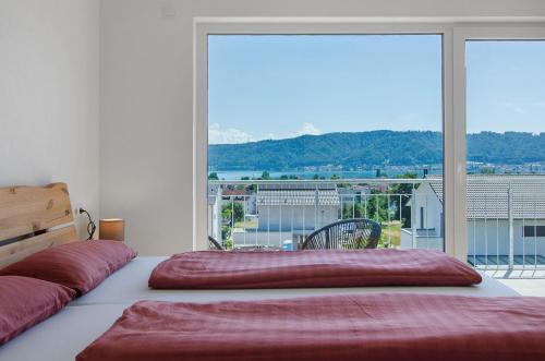 a bedroom with a bed with a large window at Ferienhaus Aura in Bodman-Ludwigshafen