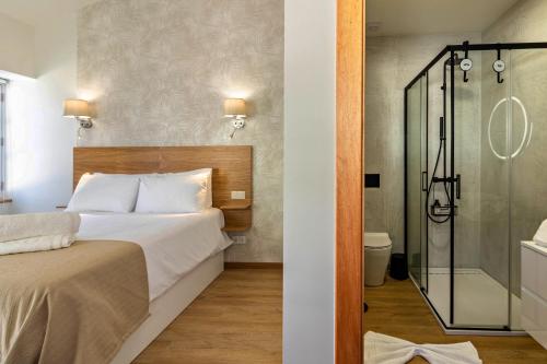 a bedroom with a bed and a shower at Casa das Andorinhas in Câmara de Lobos