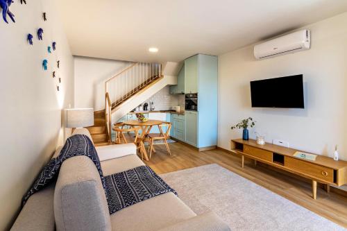 a living room with a couch and a tv at Casa das Andorinhas in Câmara de Lobos