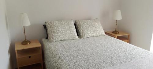 a bedroom with a bed with two lamps on tables at Vivenda Chã in Ribeira Funda