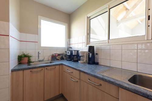 a kitchen with wooden cabinets and a sink and a window at Gite Le Bérierot avec piscine in Ouzous