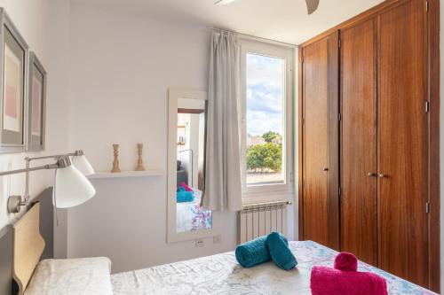 a bedroom with a bed with colorful pillows on it at Apartamento Llenaire cerca playa in Port de Pollensa