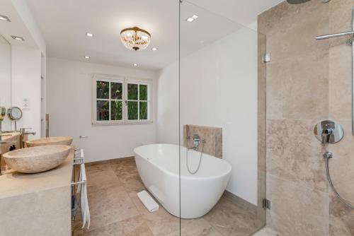 a bathroom with a tub and a shower and a sink at Le Mas d'Aiguebelle in La Croix-Valmer