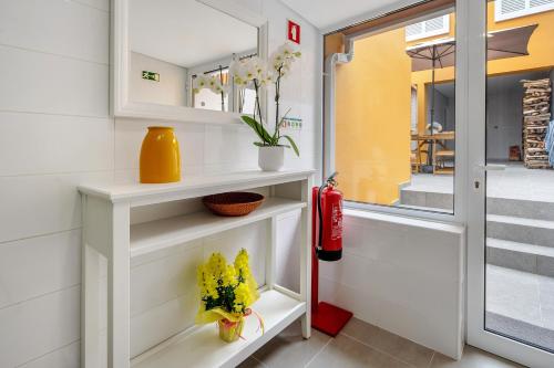 a room with white shelves with flowers and a fire extinguisher at V L P Amorim in Ponta Delgada