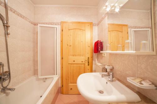 a bathroom with a sink and a toilet and a tub and a mirror at Sonnenparadies Apartement 2 in Saltusio