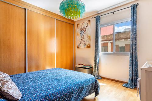 a bedroom with a blue bed and a window at San Antonio in Sedaví