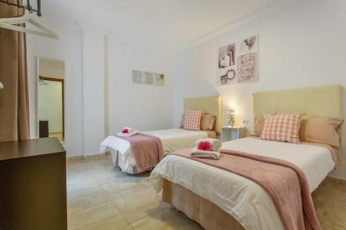 a hotel room with two beds and a table at Apartamento Rolycar 101 in Icod de los Vinos