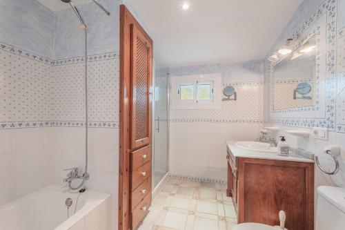 a bathroom with a tub and a toilet and a sink at Es Rafal in Santa Margalida