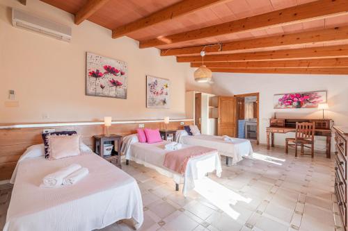a bedroom with two beds and a piano at Es Rafal in Santa Margalida