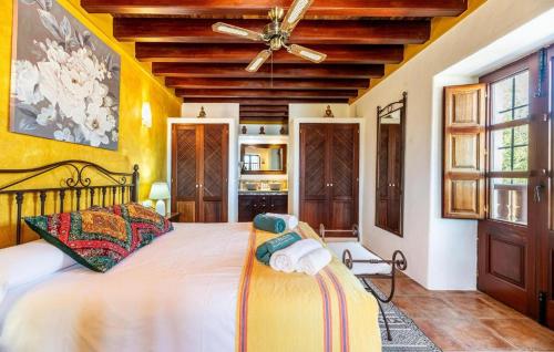 a bedroom with a large bed and a ceiling fan at Can Andreuet in Sant Carles de Peralta