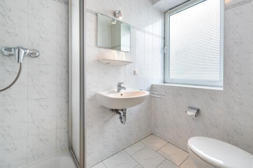 a white bathroom with a sink and a mirror at Villa Bella Vista - Meerblick 1 in Sassnitz
