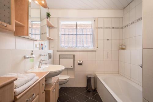 a bathroom with a sink and a tub and a toilet at Ferienwohnung Welte in Meckenbeuren