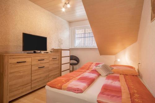 a bedroom with a bed and a flat screen tv at Ferienwohnung Welte in Meckenbeuren