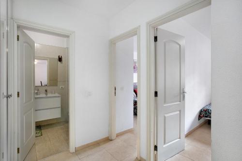 a bathroom with two white doors and a sink at Beach Front Apartment Puertito in Puertito de Güímar